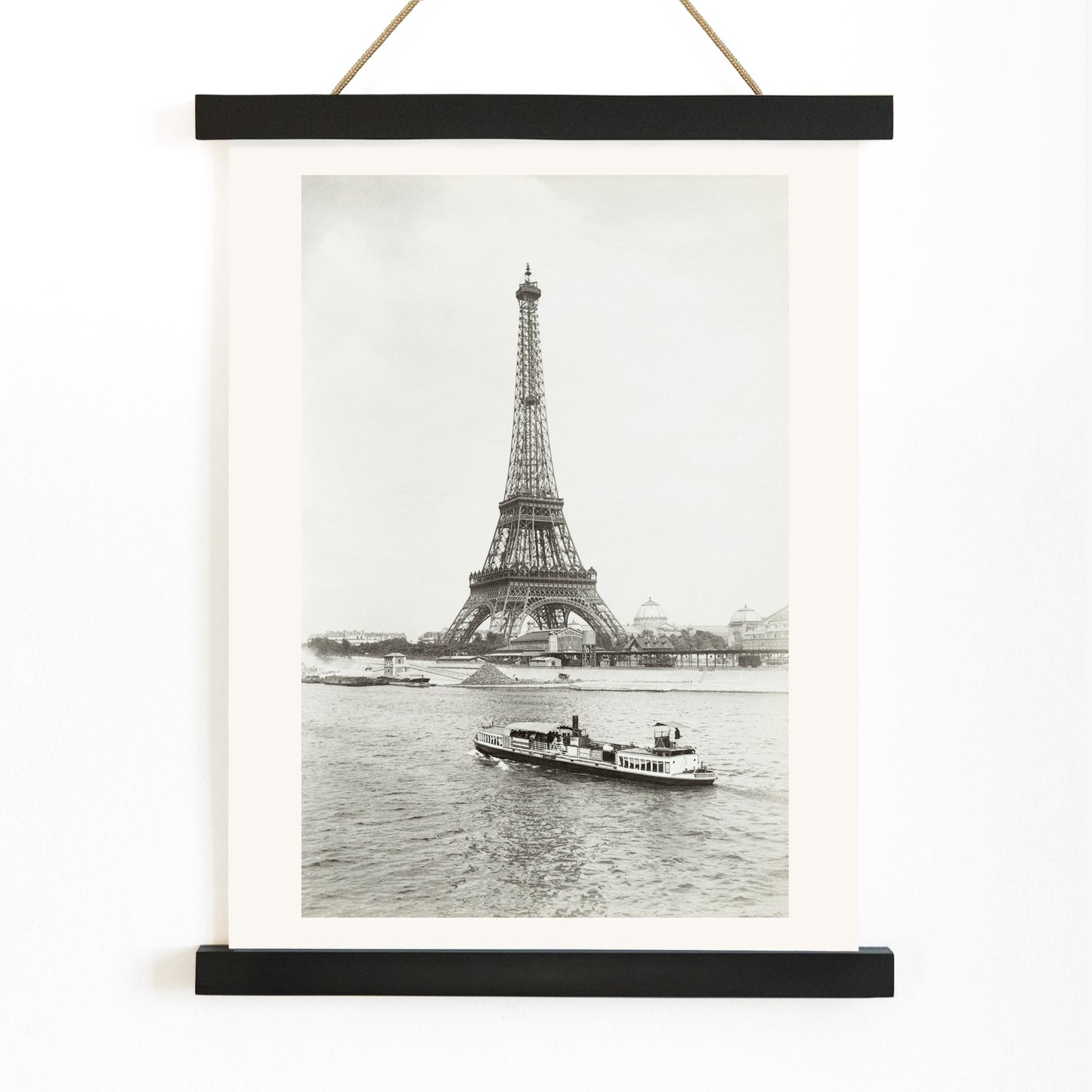 Black and white photograph and poster of the Eiffel Tower in Paris with a vintage boat on the Seine river wall decor artwork, with wooden magnetic frame on white background