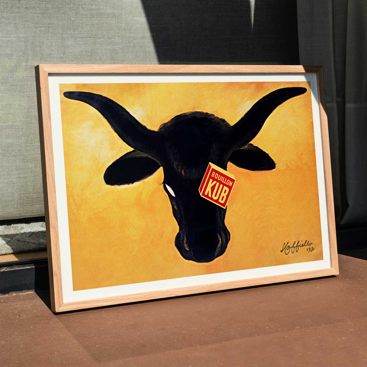 Leonetto Cappiello Bouillon Kub poster featuring a bold black bull on vivid orange background with red label, framed and displayed in modern living room decor