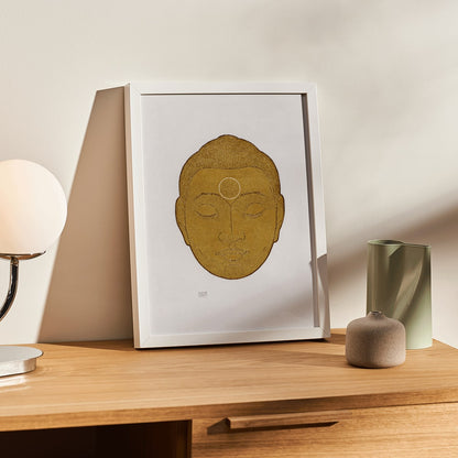 Serene golden Buddha head artwork with closed eyes by Reijer Stolk titled Head of Buddha on white background, framed and displayed in modern living room decor