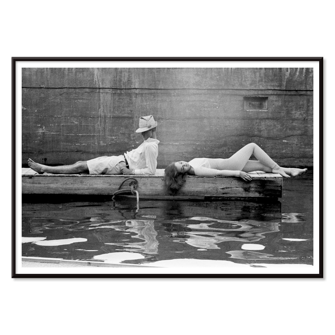 Marquess of Tavistock Henry Robin Ian Russell and Henrietta Tiarks relaxing on a dock in Bermuda by Toni Frissell poster, with black aluminium frame on white background