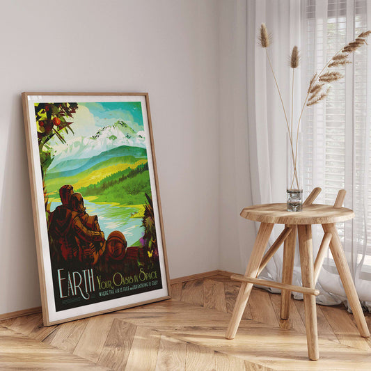 Two people in spacesuits admire a lush green landscape with mountains and a lake Earth Your Oasis in Space by NASA poster artwork, framed and displayed in home decor