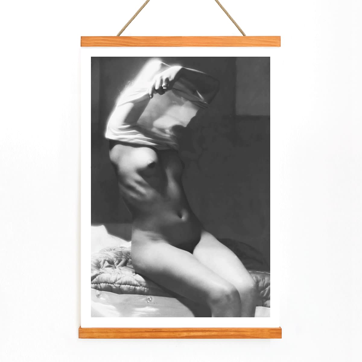 Before going to bed by Michael Heumuller poster showing a person gracefully removing a shirt in a dimly lit room, with wooden magnetic frame on white background