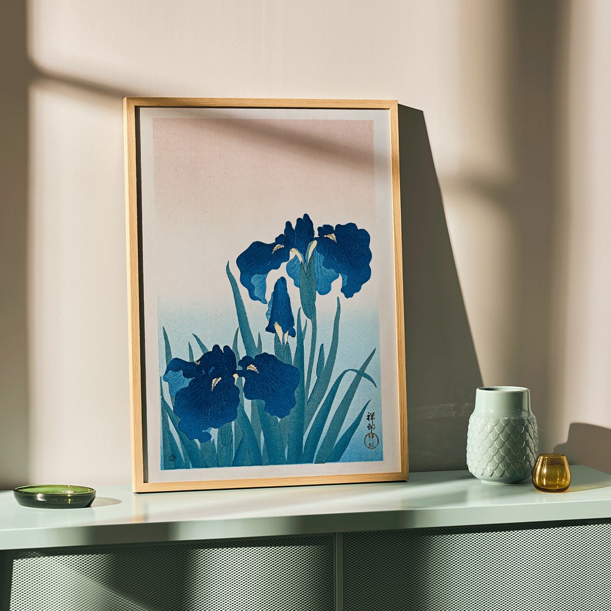 Poster of vibrant blue irises with green leaves on a gradient background artwork Blue Irises by Ohara Koson, framed and displayed in home decor