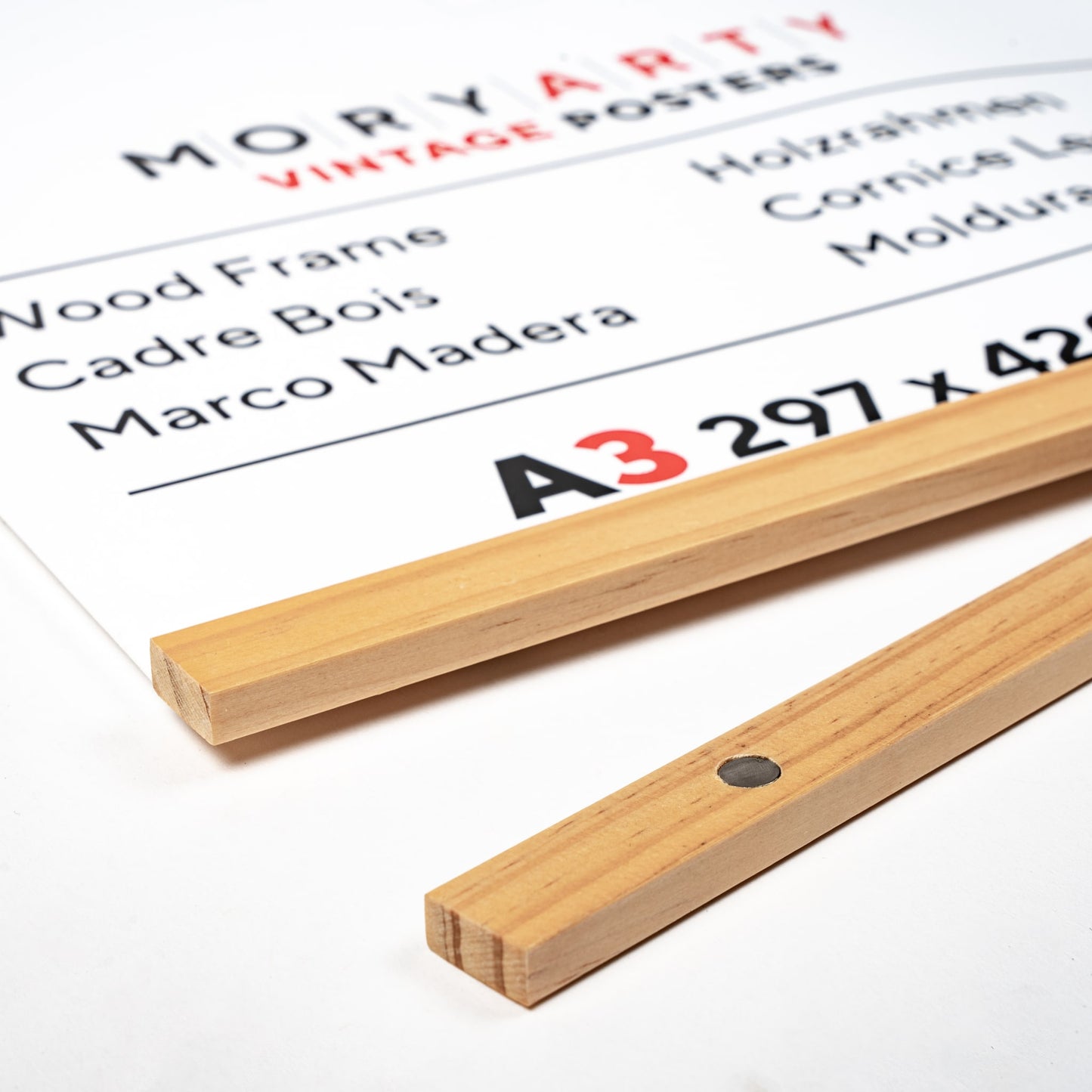 Light pine magnetic wood frame with two solid wood bars and rope for hanging, displaying a poster on a wall in a modern, minimalist style, back corner closeup picture