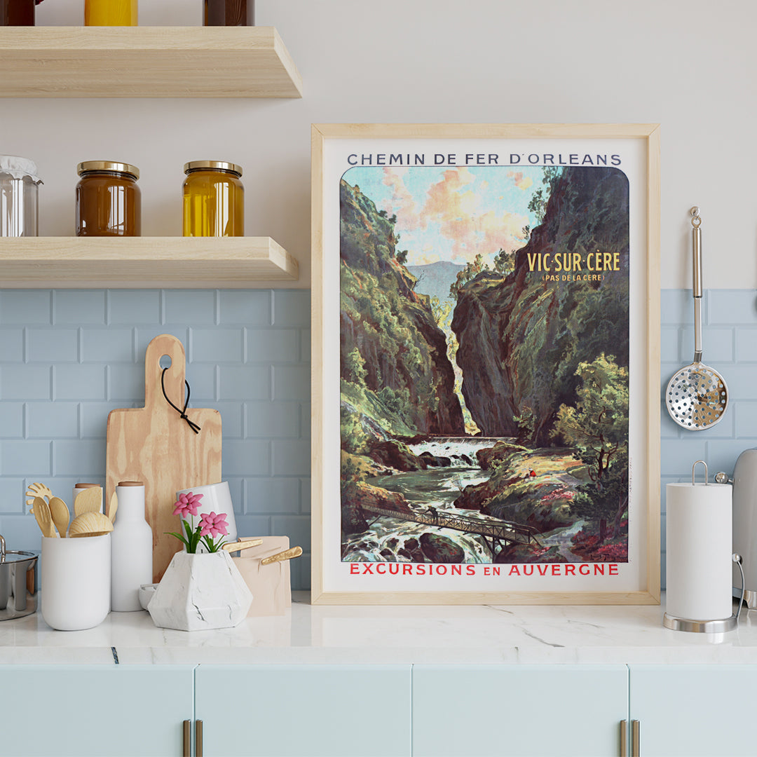 Scenic mountain gorge with river and footbridge in Vic Sur Cere travel poster by Louis Tauzin artwork for excursions in Auvergne, framed and displayed in home decor