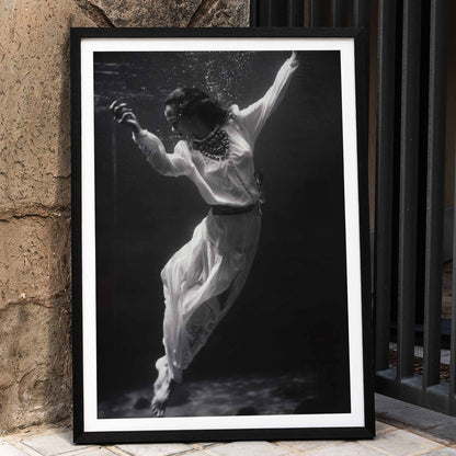 Black and white artwork of a fashion model floating underwater in dolphin tank Marineland Florida by Toni Frissell, framed and displayed in home decor