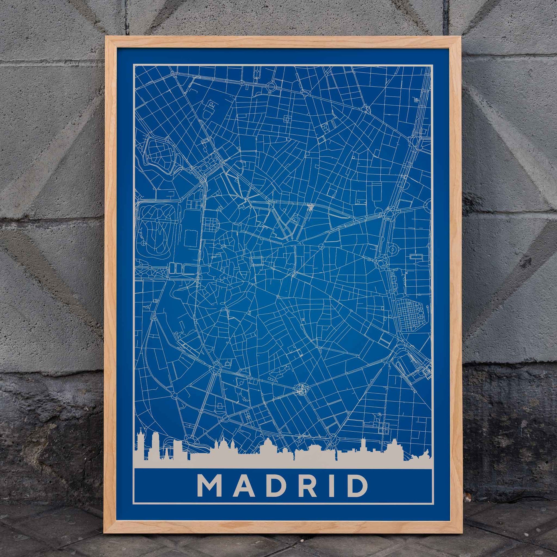 Minimalist Madrid Map by Artist Name blue and white city layout with silhouettes and street details poster, framed and displayed in home decor