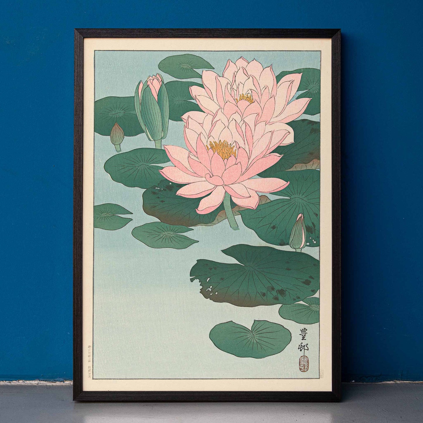 Poster of pink water lilies and green lily pads on calm pond from Flowering Water Lily by Ohara Koson, framed and displayed in home decor