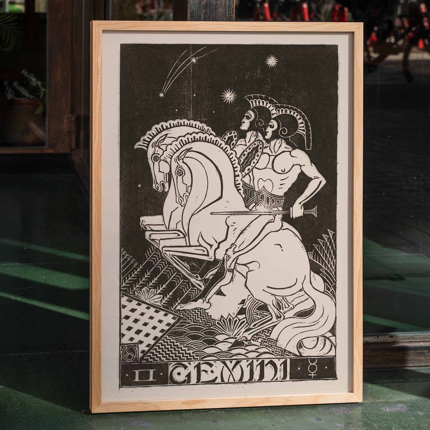 Gemini zodiac artwork by Henri van der Stok featuring two figures with chariot and horses under stars detailed black and white illustration, framed and displayed in home decor