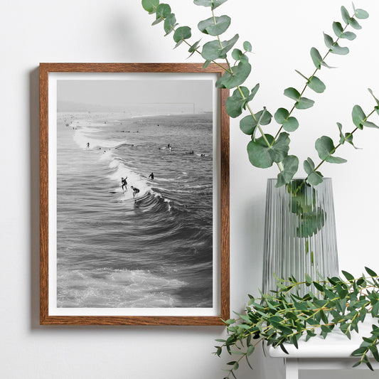 Black and white surfers riding waves at Venice Beach coastal wall art poster ideal for home decor, framed and displayed in home decor