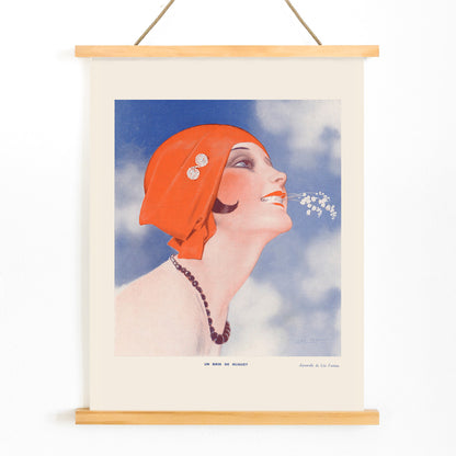 Poster of Un Brin de Muguet by Leo Fontan showing a smiling woman in a red headscarf holding lily of the valley in her mouth, with wooden magnetic frame on white background